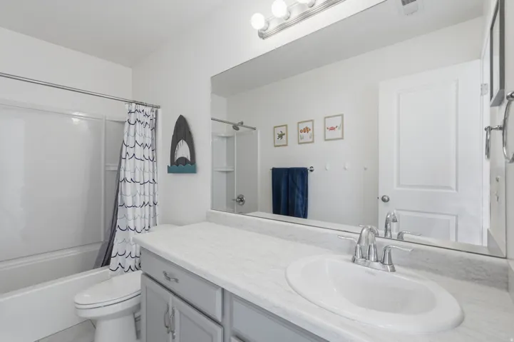 Vanity with integrated sink, chrome faucet, and expansive mirror