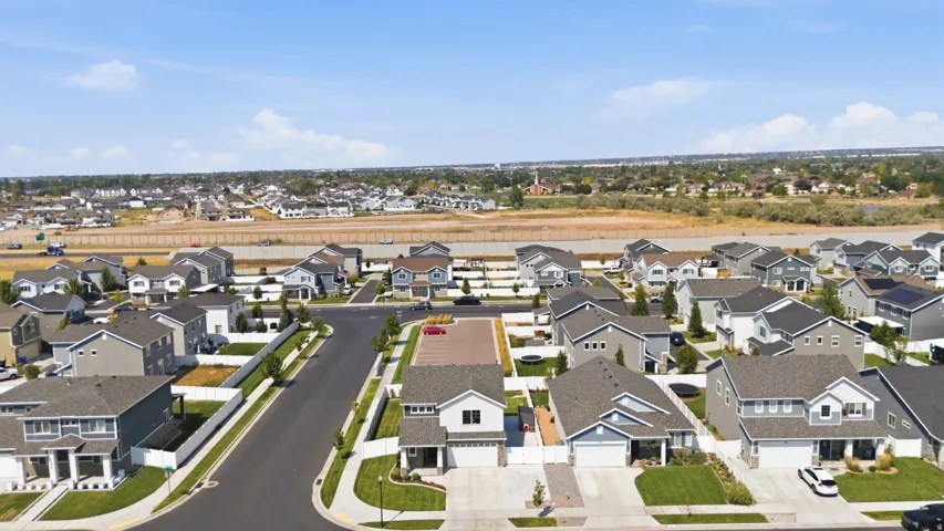 Aerial perspective of a developed residential community with multiple single-family homes, paved streets, and manicured landscaping