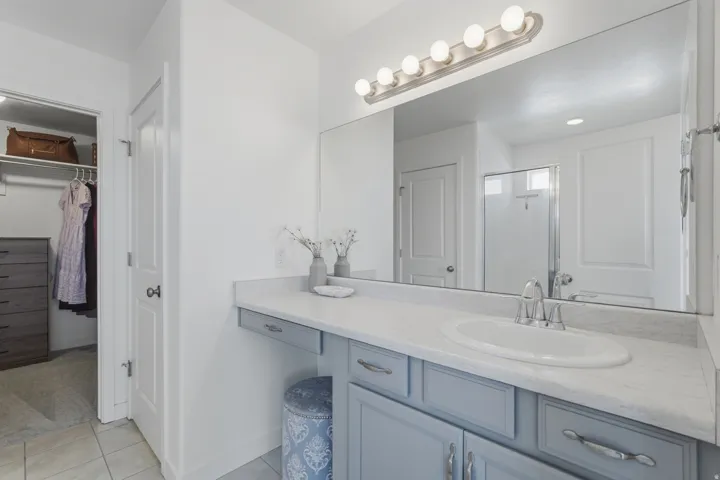 Vanity with an integrated sink, light-toned countertop, and blue cabinetry