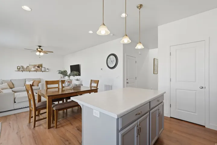 Open-concept living space with wood-finish flooring, recessed lighting, and a ceiling fan