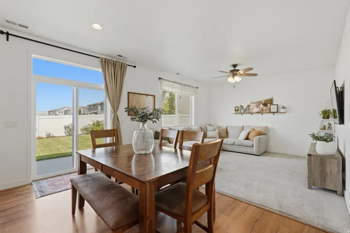 Open-concept living space with wood-finish flooring, recessed lighting, and a ceiling fan