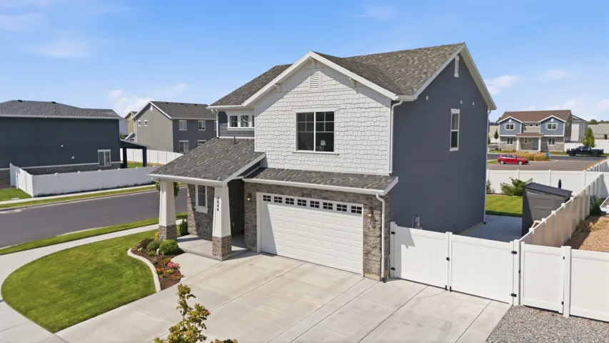 Two-story residence featuring a covered entry, stone facade accents, and a two-car garage