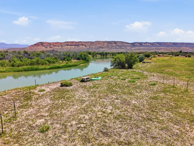Waterfront property featuring a river, natural vegetation, and distant mountain range