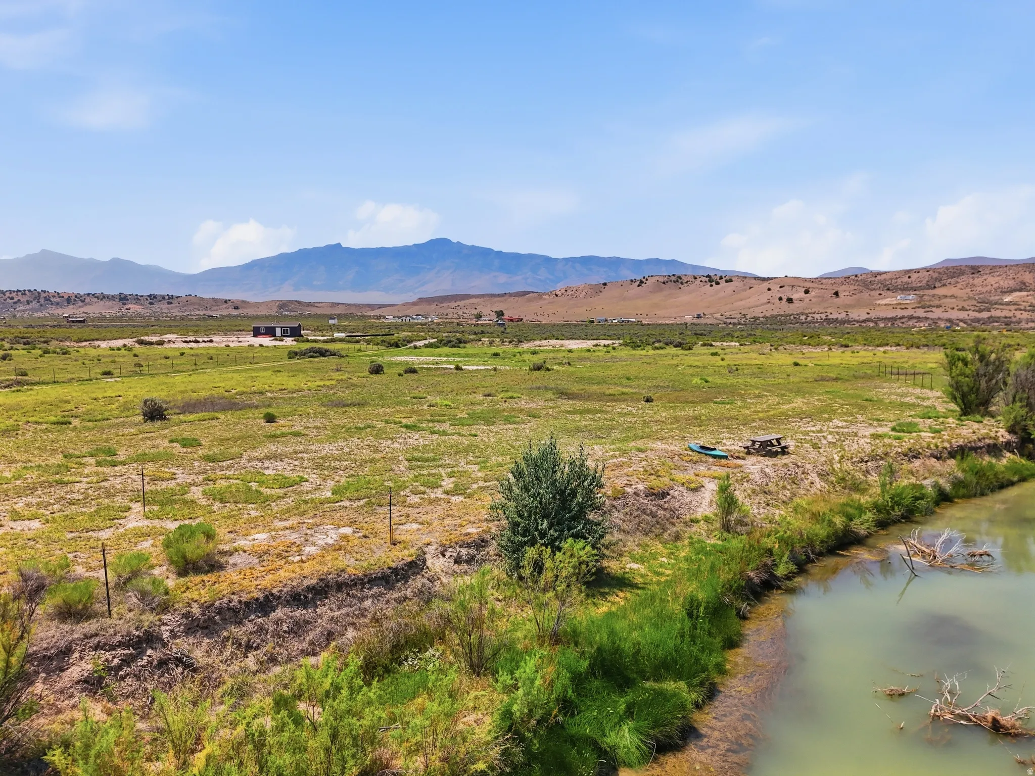 Expansive land parcel featuring natural waterways and distant mountain scenery