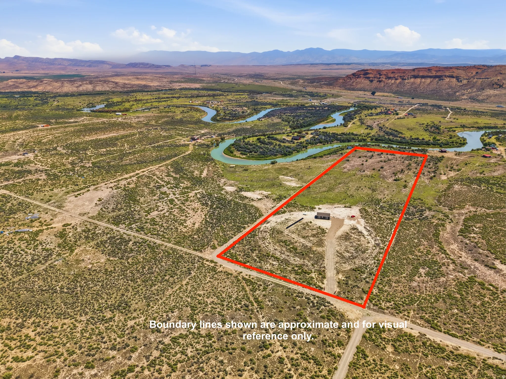 Expansive parcel featuring a river frontage, a flat building pad, and distant mountain backdrops