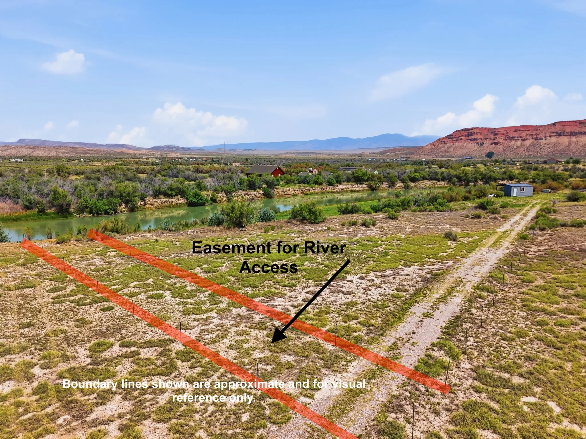 Expansive undeveloped land featuring direct river access, a gravel pathway, and distant mountain backdrops