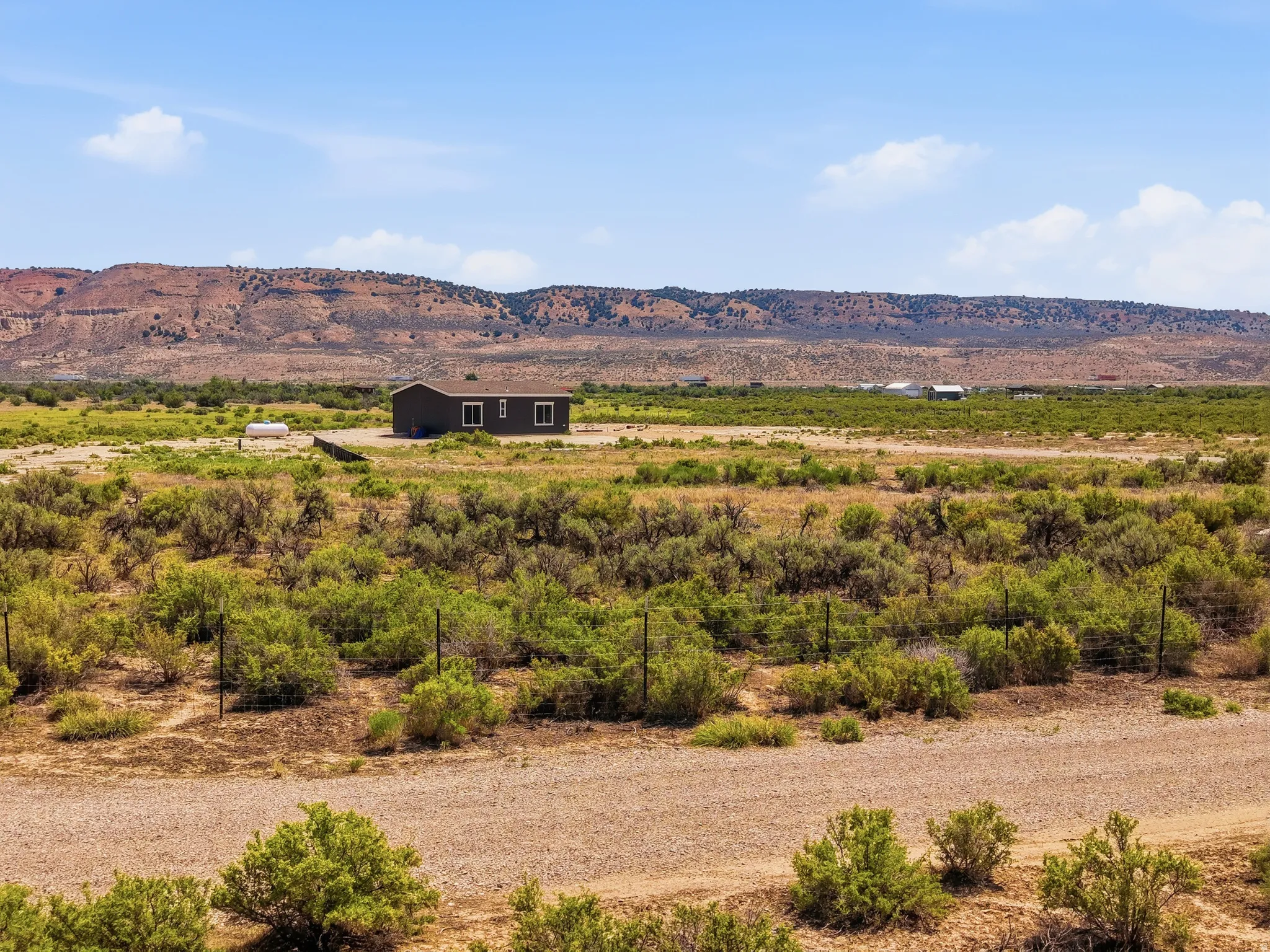 Expansive landscape featuring a single-story dwelling with a dark-toned exterior