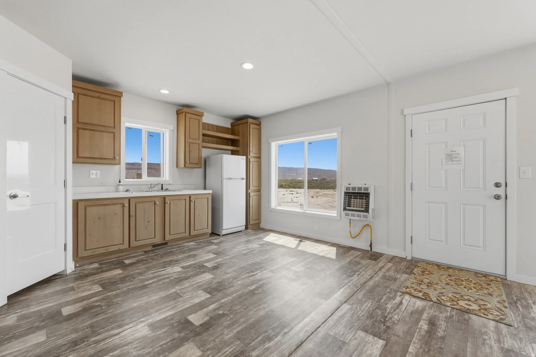 Wood-finish flooring, recessed lighting, and kitchen cabinetry with open shelving