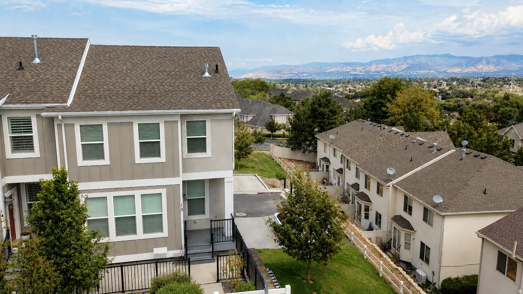 Townhome exterior featuring multi-toned siding, a brown shingle roof, and multiple windows