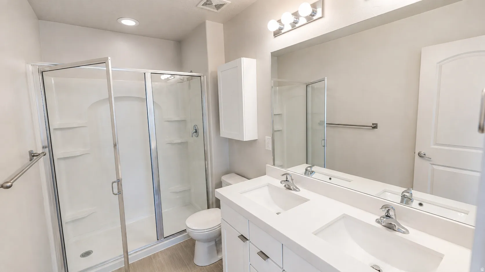 Dual vanity with undermount sinks, chrome fixtures, and a large mirror