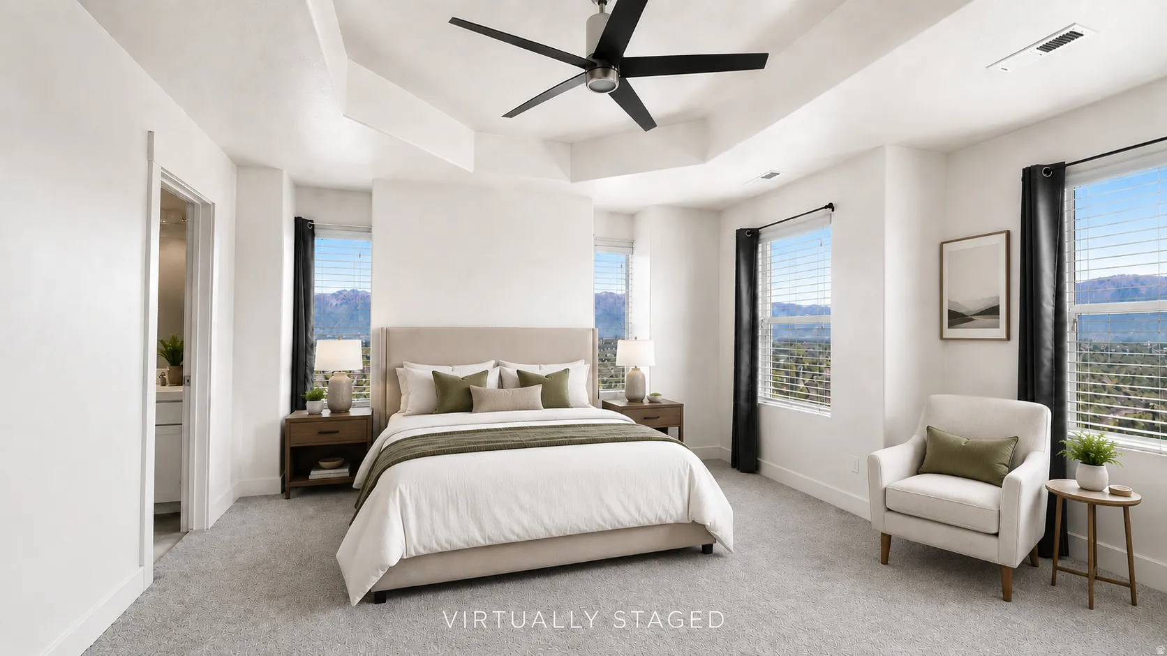 Tray ceiling with a ceiling fan, multiple windows with blinds, and light gray carpet
