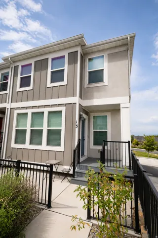 Two-story exterior with board and batten siding, stucco finish, and white trim