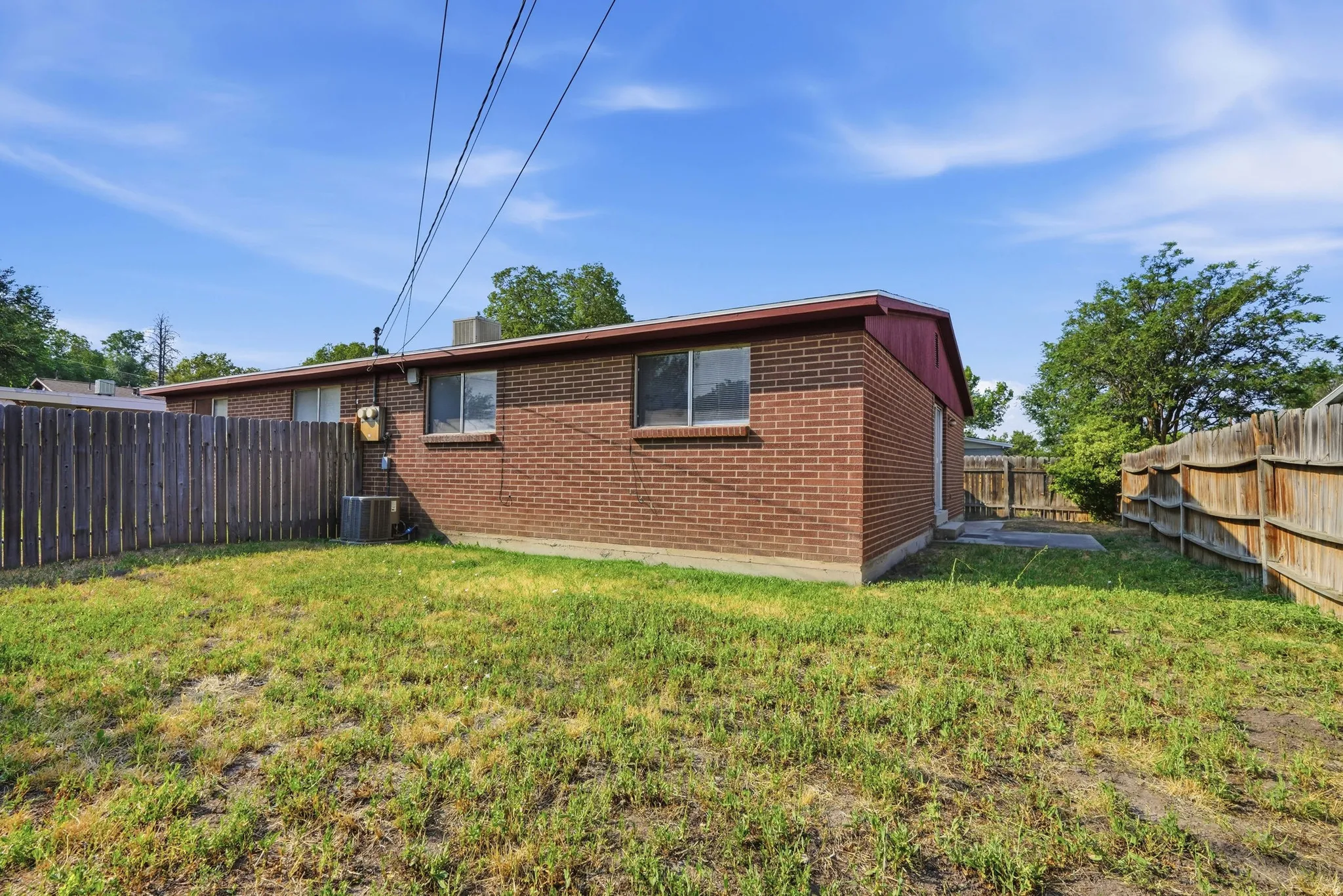Rear exterior with brick siding and a fenced yard
