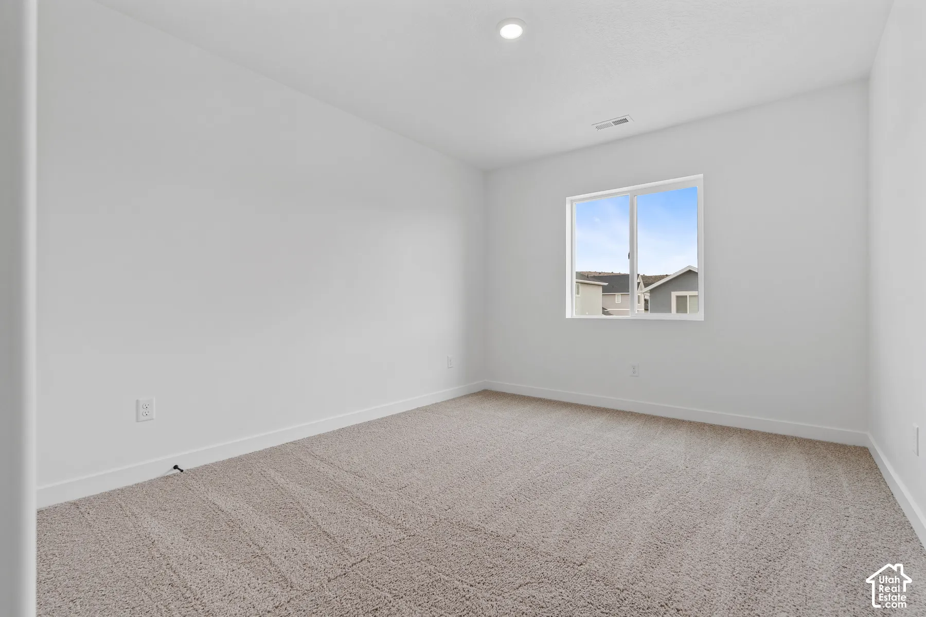 Recessed ceiling lighting, crisp white walls, and carpeting
