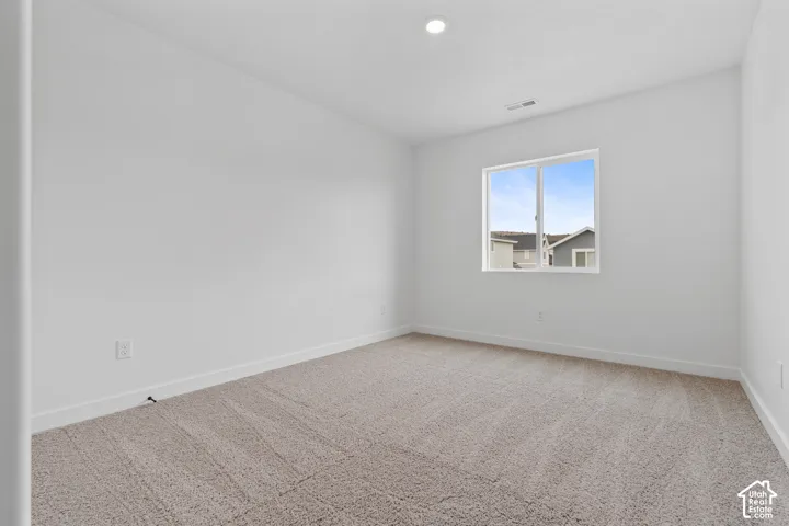 Recessed ceiling lighting, crisp white walls, and carpeting
