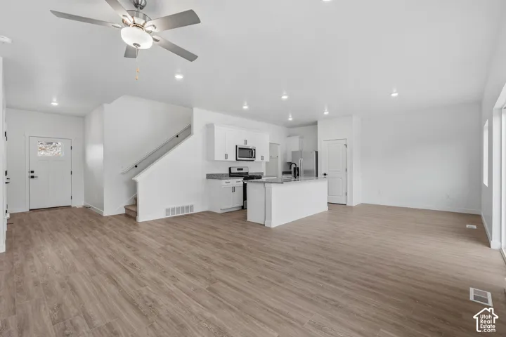 Open concept living area featuring wood-finish flooring, recessed lighting, and a ceiling fan