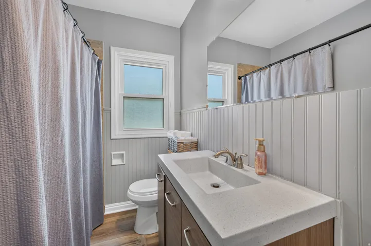 Vanity with integrated sink, wood-finish cabinetry, and brushed nickel faucet