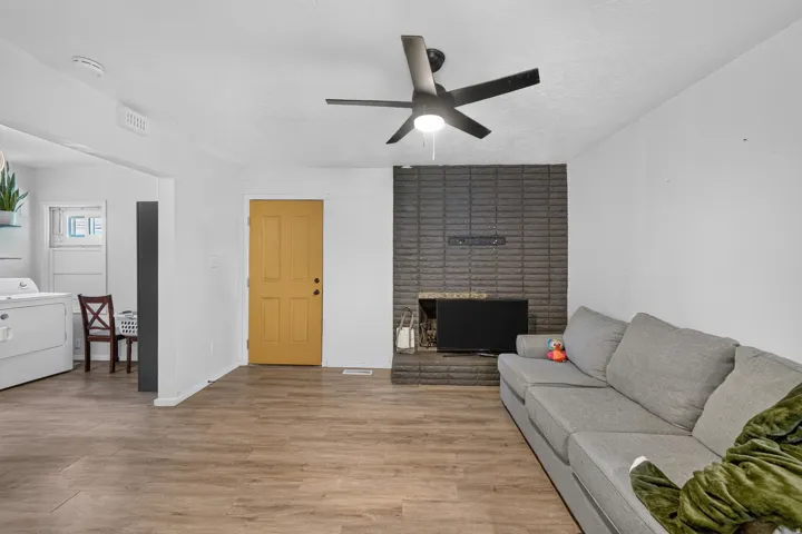 Wood-finish flooring throughout, complemented by a contemporary ceiling fan with integrated lighting