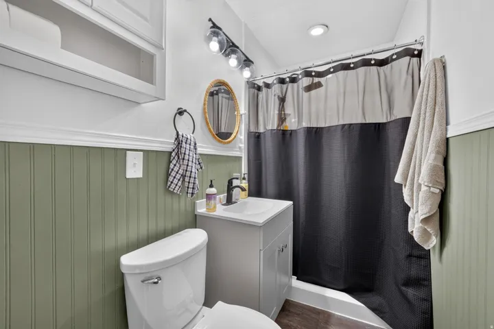 Bathroom featuring beadboard wainscoting, recessed lighting, and a vanity with a rectangular sink