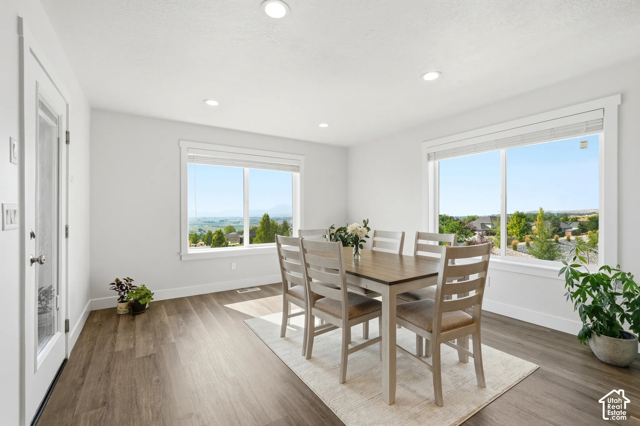Recessed lighting, wood-finish flooring, and multiple windows with a scenic backdrop