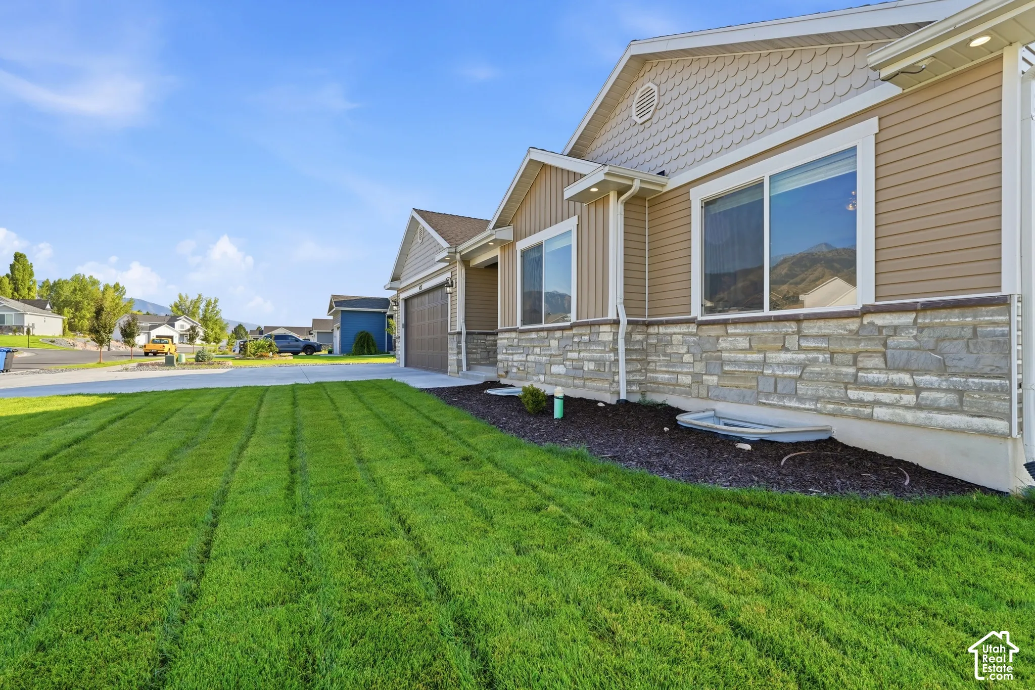 Exterior featuring horizontal siding, stone veneer accents, and shaker shingle gables