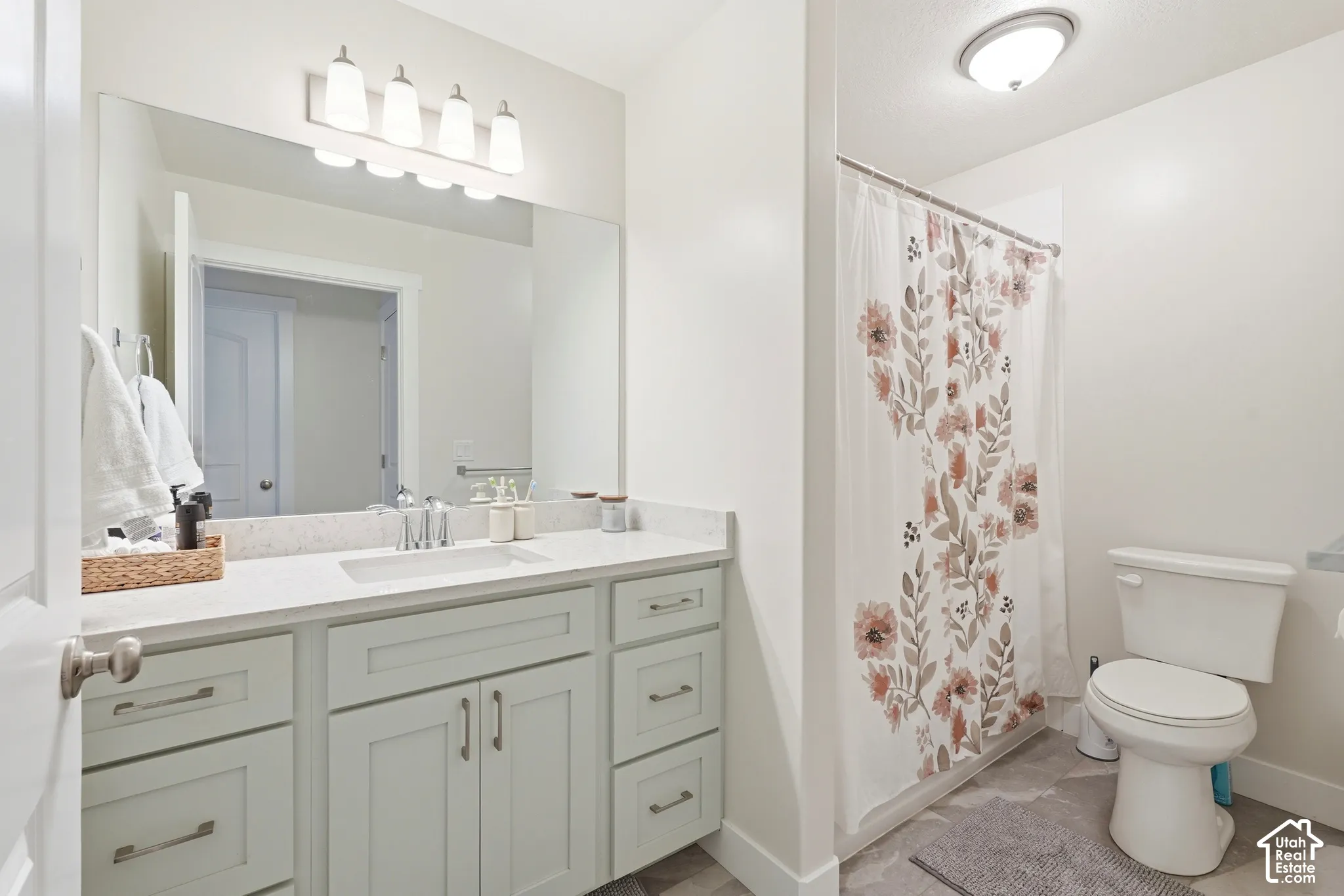 Vanity with extensive countertop space, under-mount sink, and light gray cabinetry with brushed nickel hardware