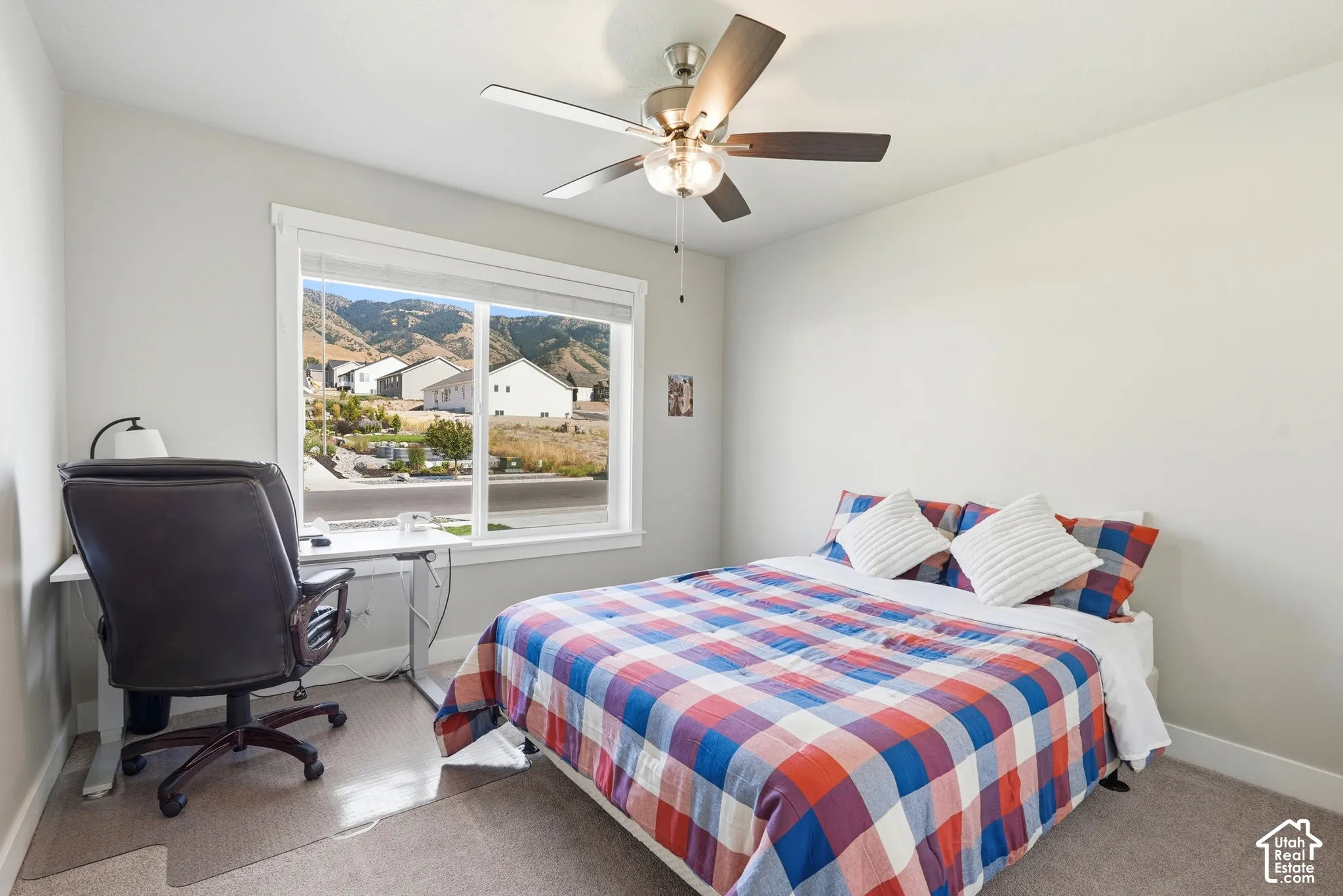 Wall-to-wall carpeting, ceiling fan with integrated lighting, and a large window with white trim