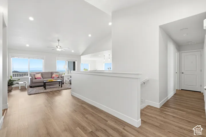 Vaulted ceilings, recessed lighting, and wood-finish flooring