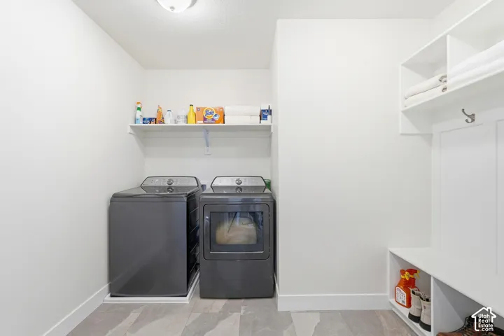 Laundry area featuring slate-look tile flooring, built-in shelving, and a bench with cubby storage