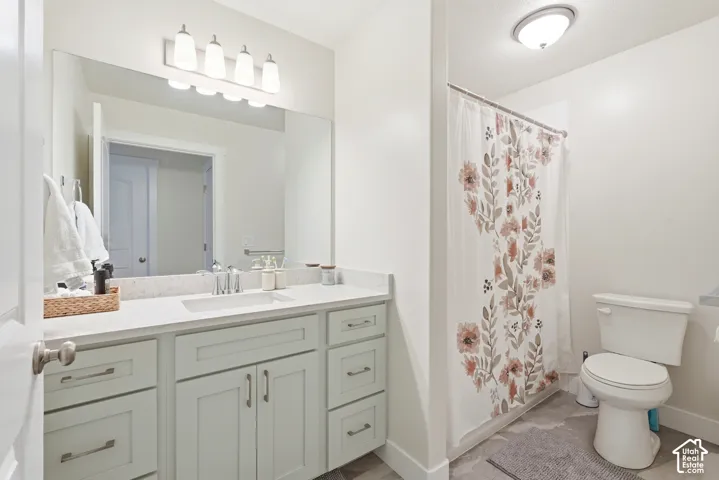 Vanity with extensive countertop space, under-mount sink, and light gray cabinetry with brushed nickel hardware