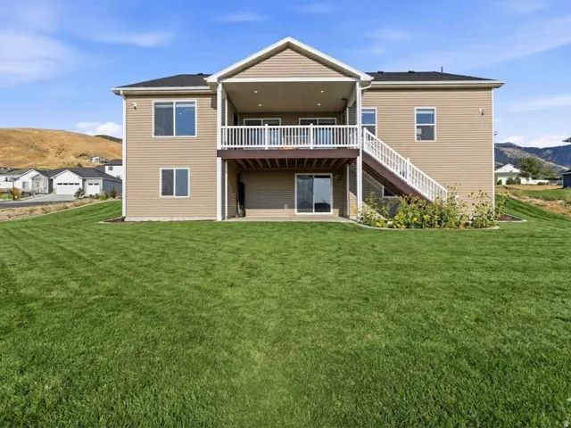 AI GENERATED to give you and idea of a green lawn with a two-story residence featuring a covered upper deck and lower patio