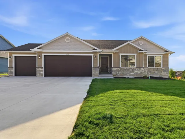 Multi-material exterior with stone accents, two-car garage, and an additional single-car garage