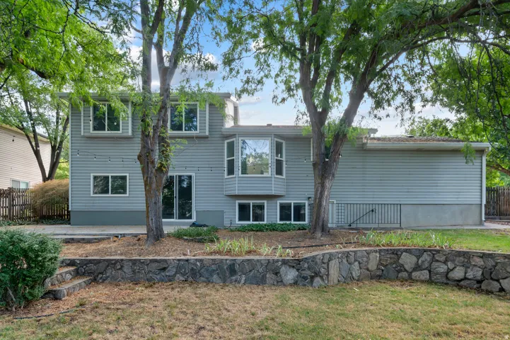 Vinyl siding exterior with multiple windows, a bay window, and a sliding glass door