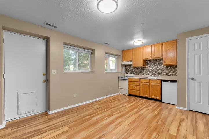 Full kitchen featuring wood cabinetry, white appliances, and a tiled backsplash