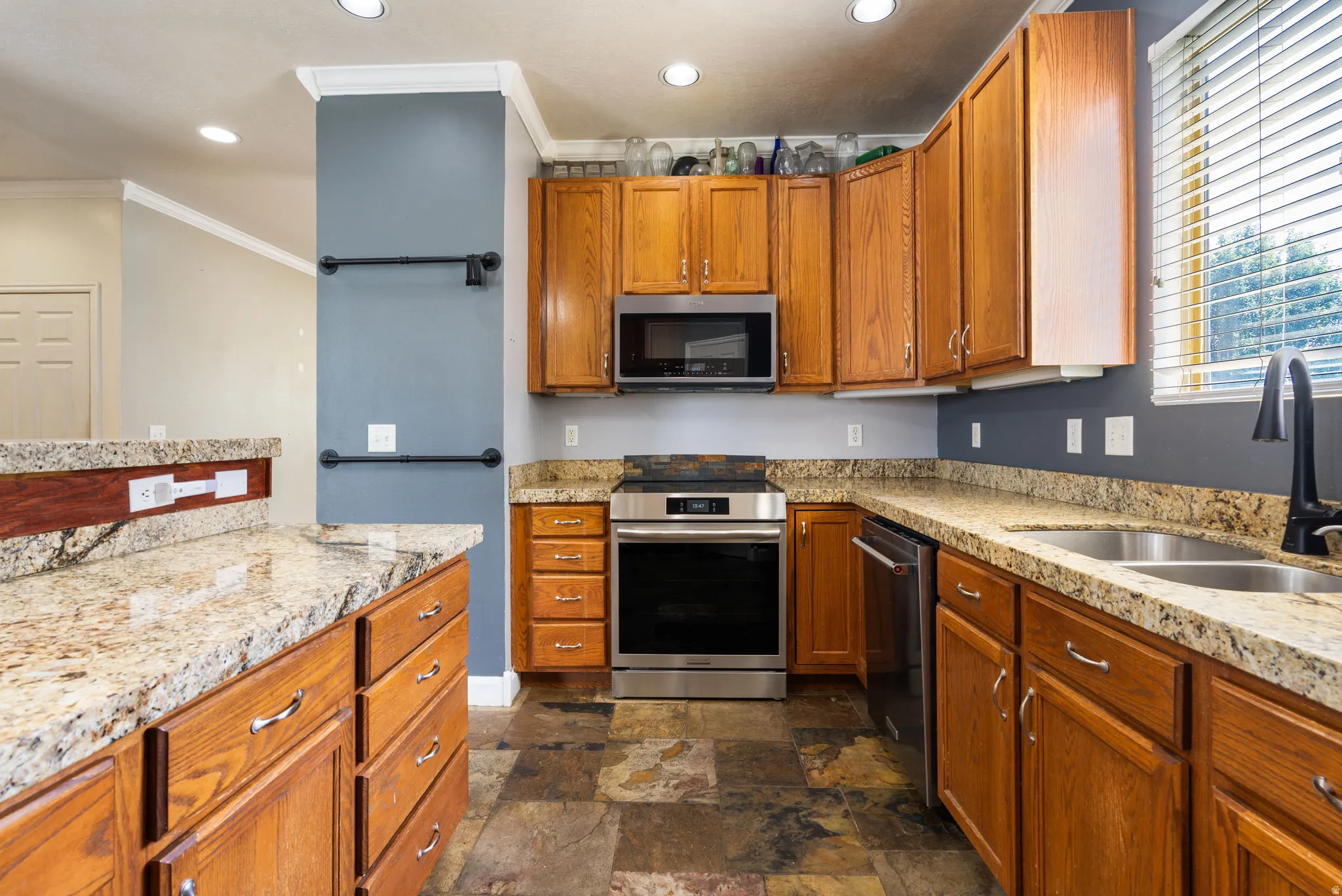 Wood-finish cabinetry complemented by light-toned, speckled countertops