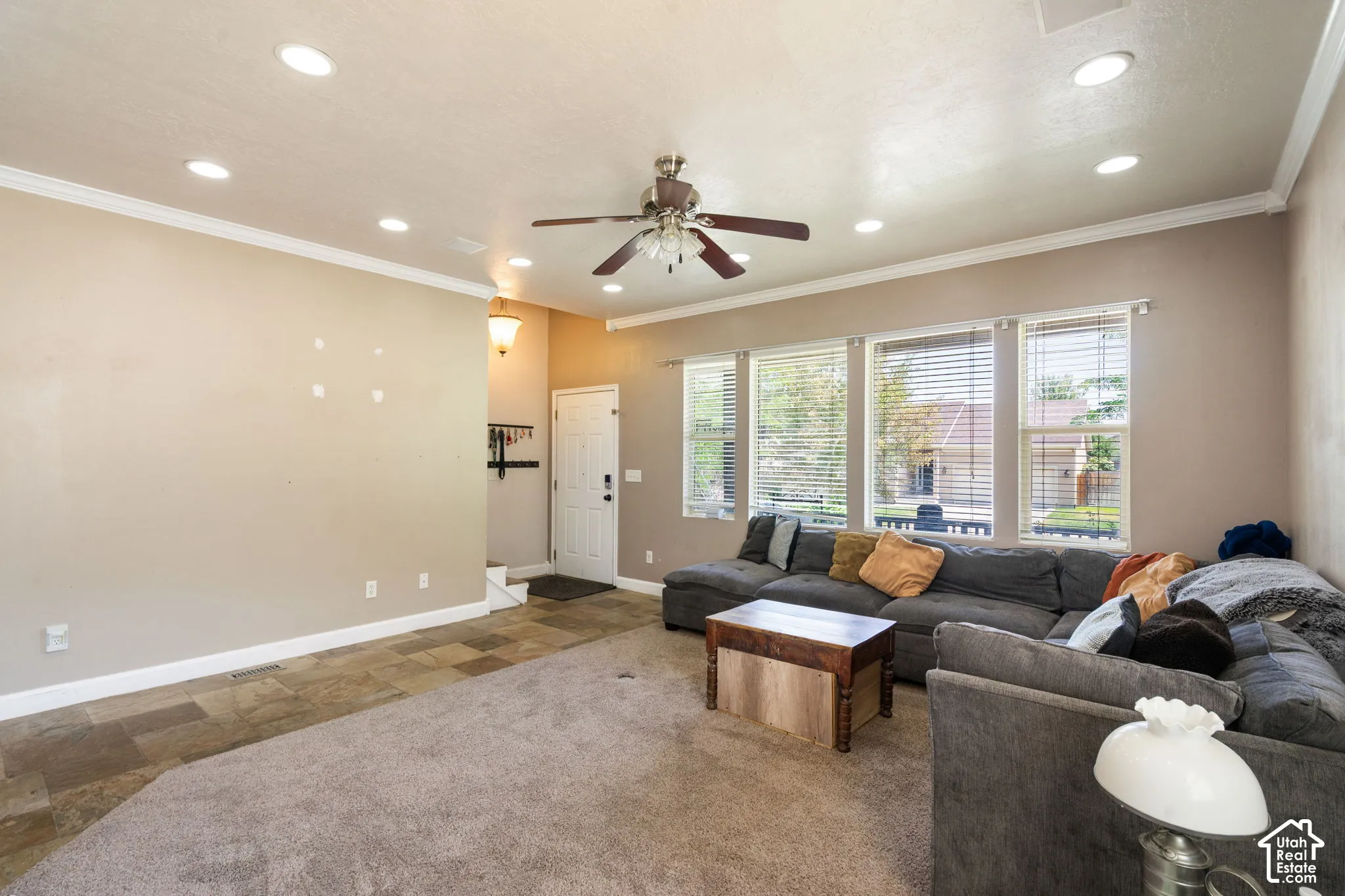 Recessed ceiling lighting, crown molding, multiple windows with blinds, a ceiling fan, and carpeted flooring