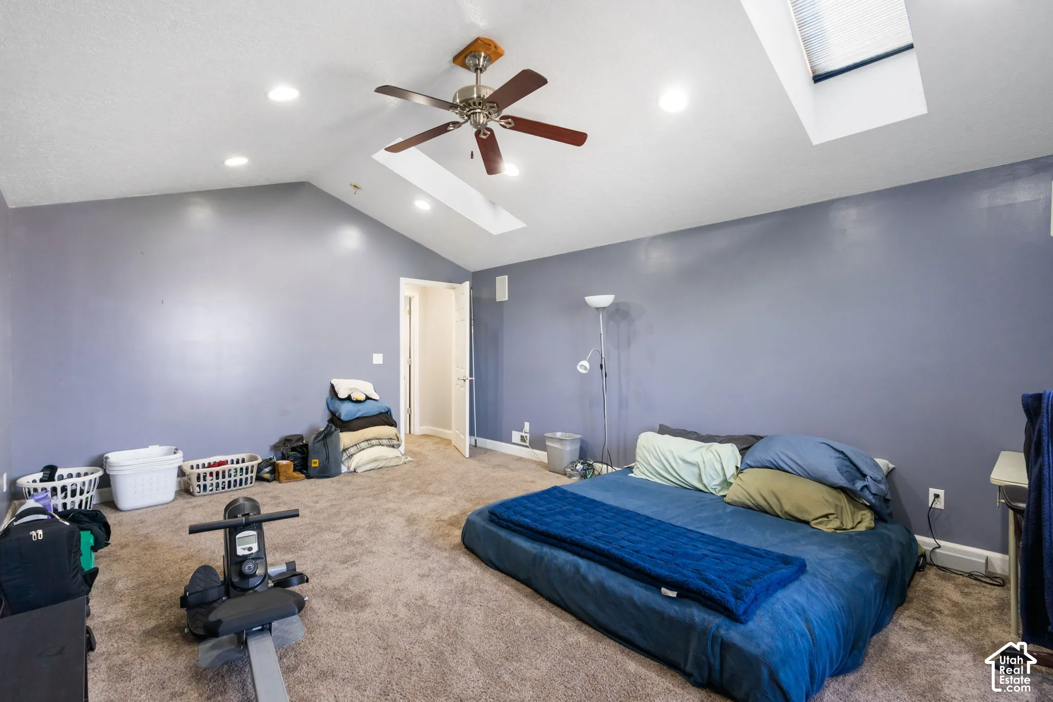 Vaulted ceiling with recessed lighting, skylight, ceiling fan, and carpeted flooring