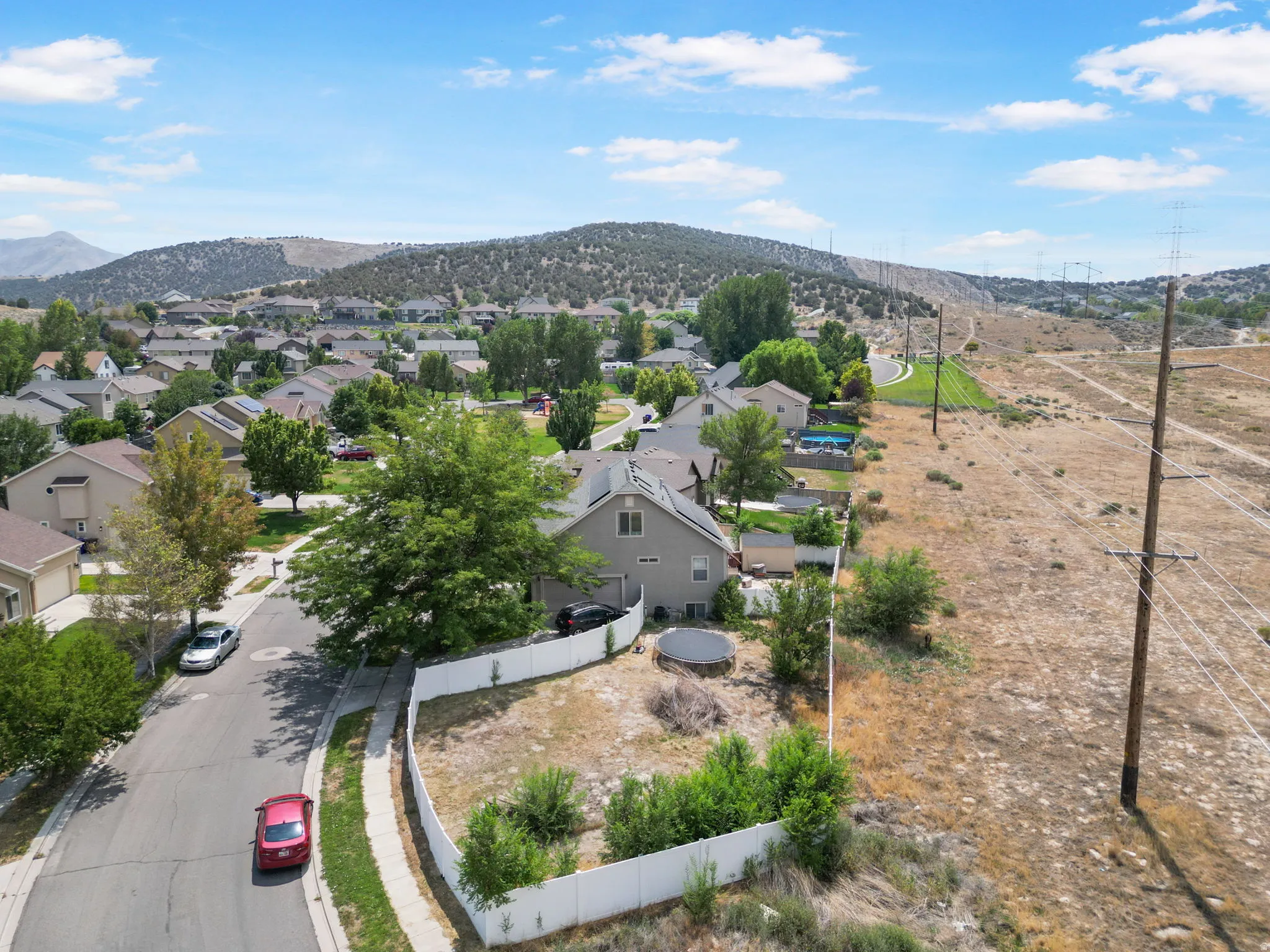 Residential setting with established homes, paved streets, and mountainous terrain