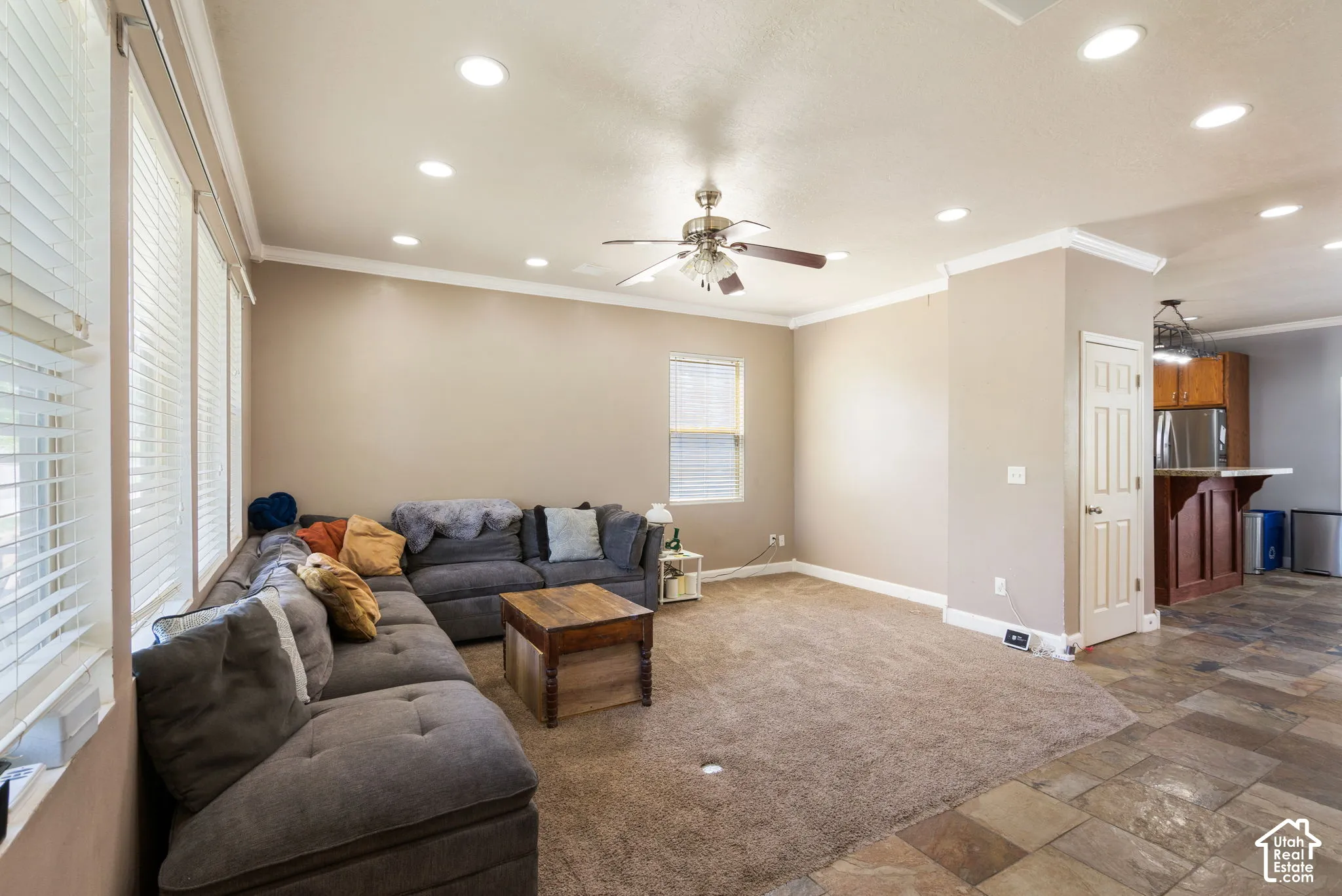 Recessed lighting, ceiling fan, crown molding, multiple windows with blinds, and durable tile flooring