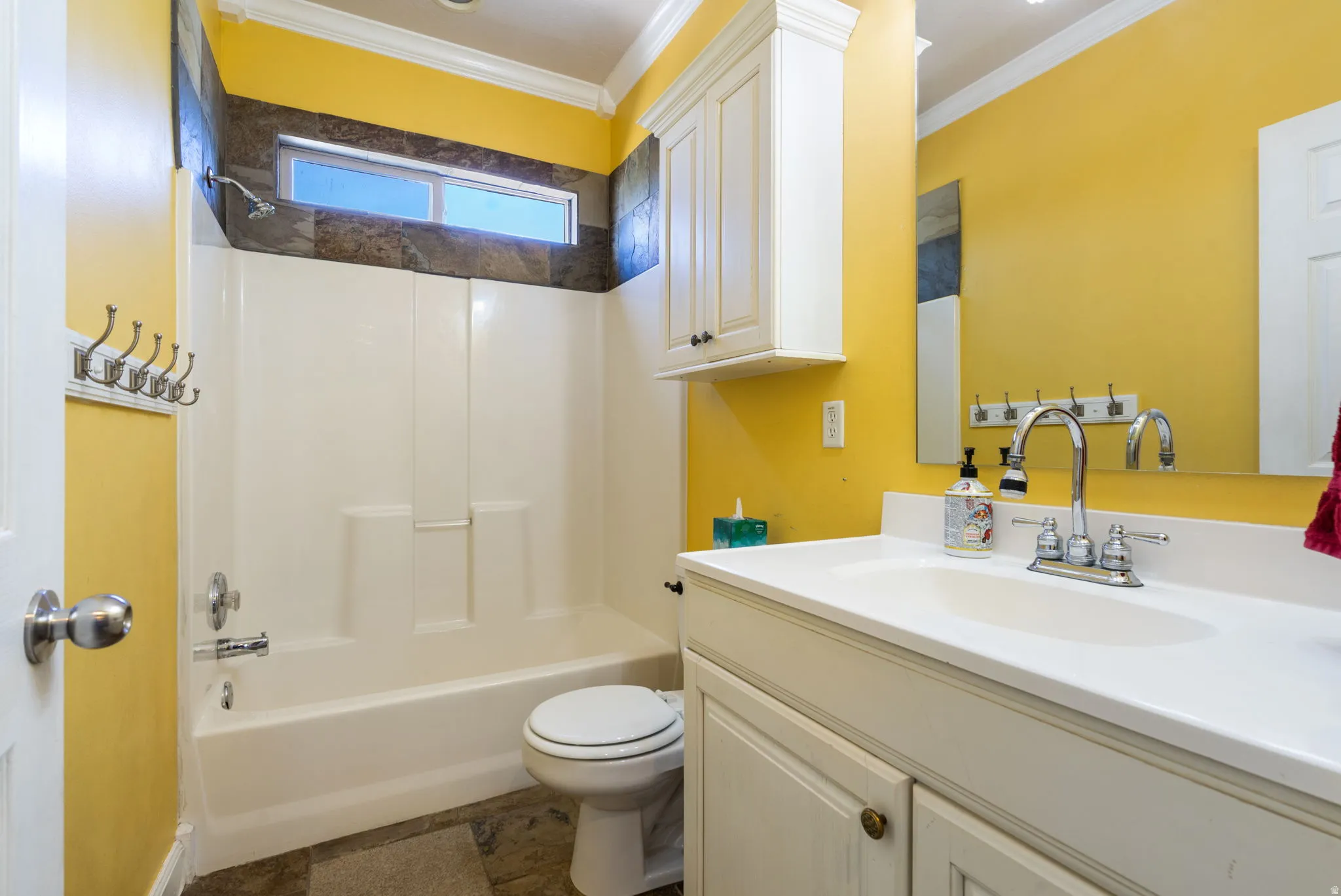 White vanity with integrated sink, chrome faucet, and white cabinetry
