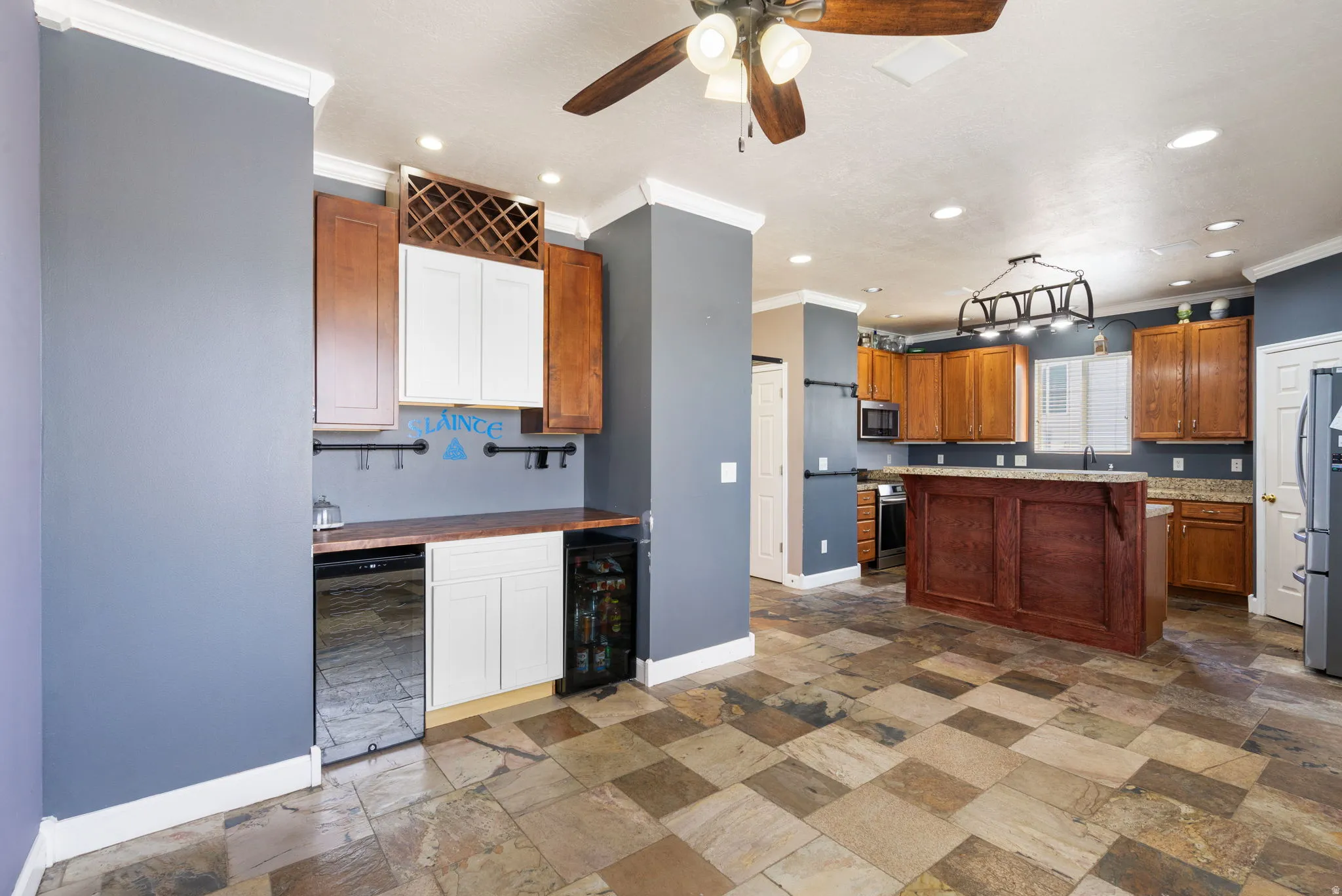 Checkerboard tile flooring, built-in beverage refrigerator, wood cabinetry, built-in wine rack, and recessed lighting