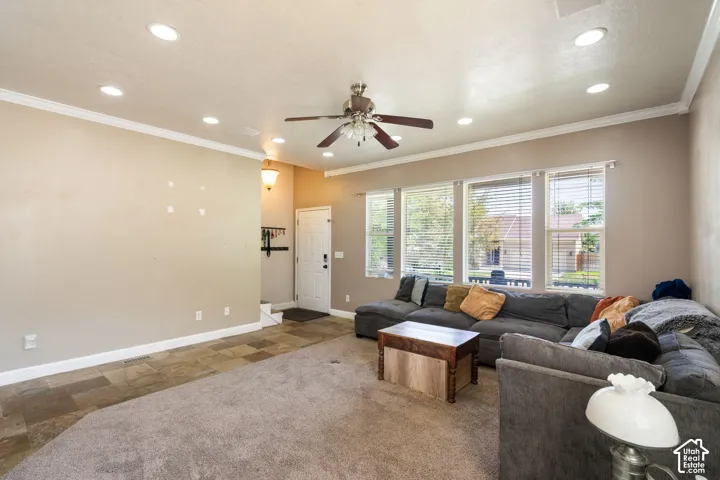 Recessed ceiling lighting, crown molding, multiple windows with blinds, a ceiling fan, and carpeted flooring