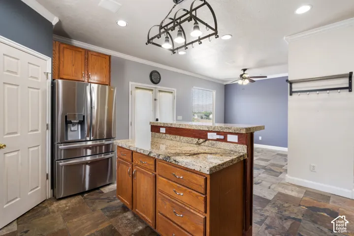Stainless steel French door refrigerator, wood-finish cabinetry, granite countertops, and recessed lighting