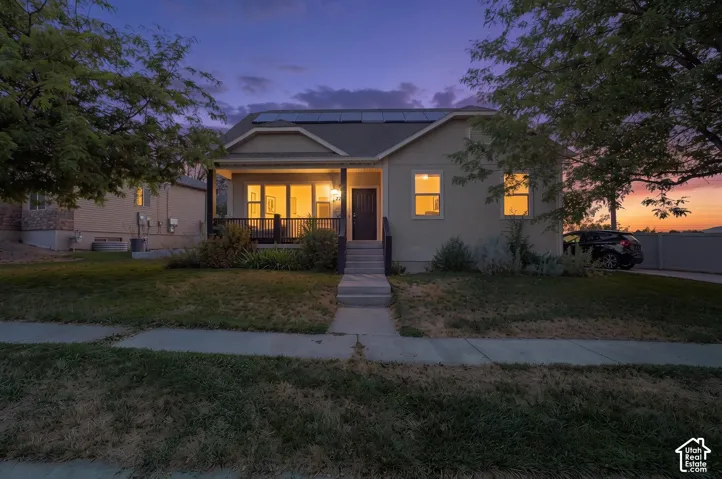Front facade with a covered porch, solar panels, and a concrete pathway