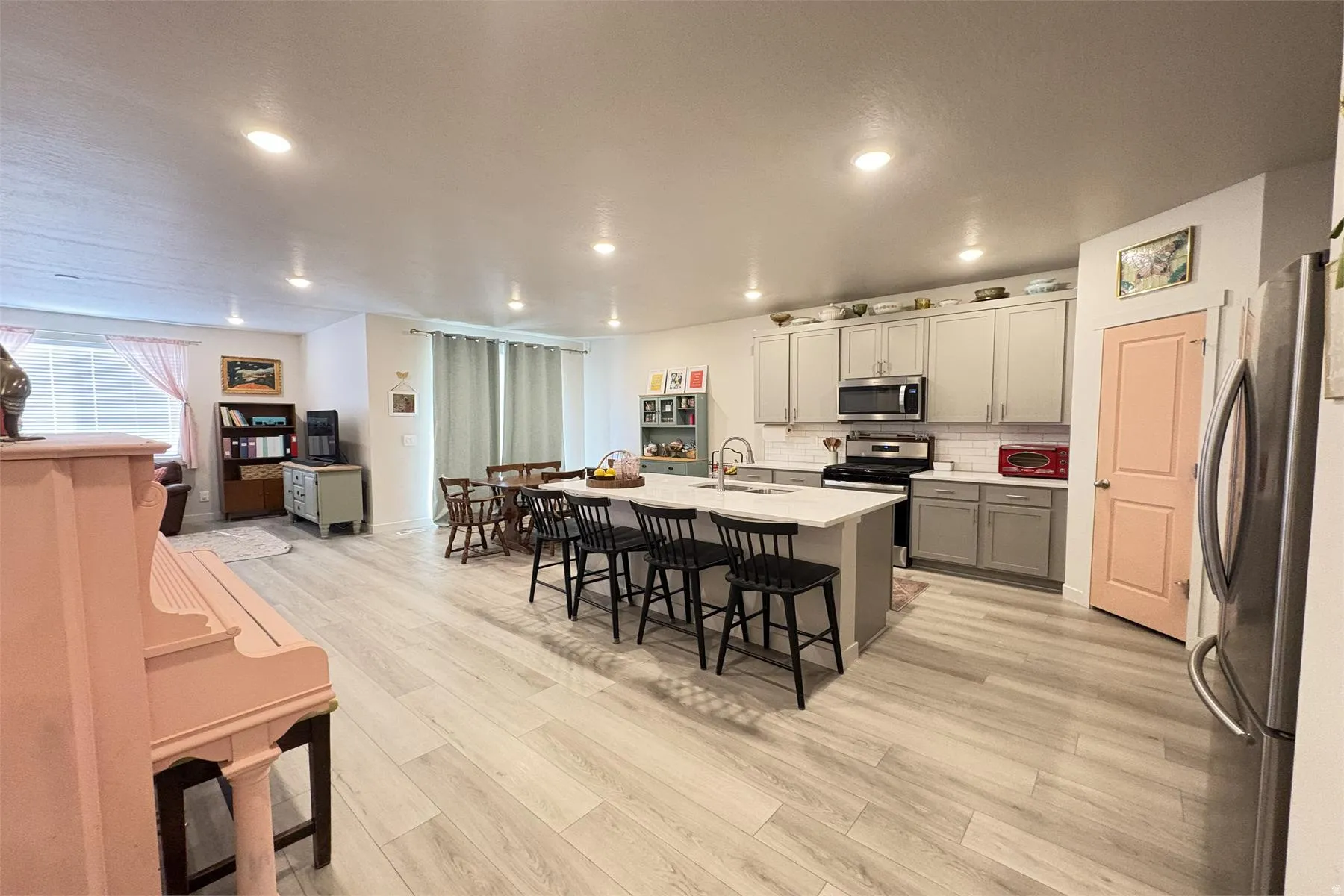 Open-concept living space featuring wood-finish flooring, recessed lighting, and large windows