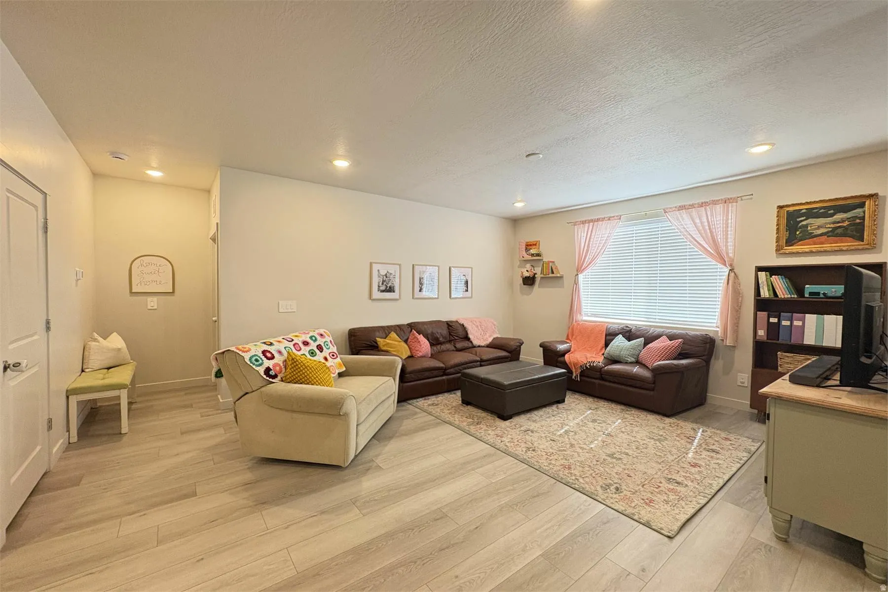 Recessed lighting, wood-finish flooring, and a large window with blinds