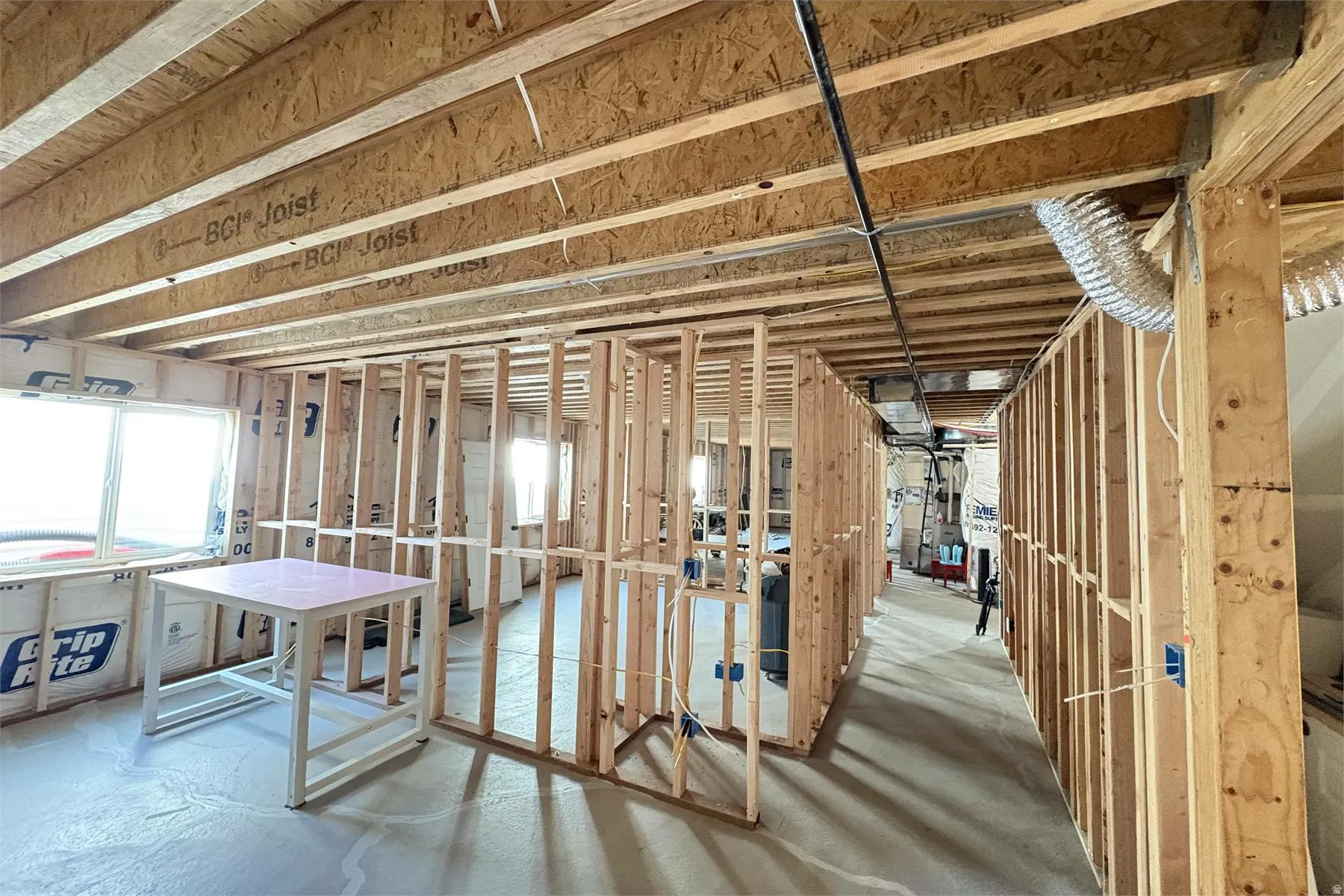 Framed interior with visible structural joists and multiple window openings