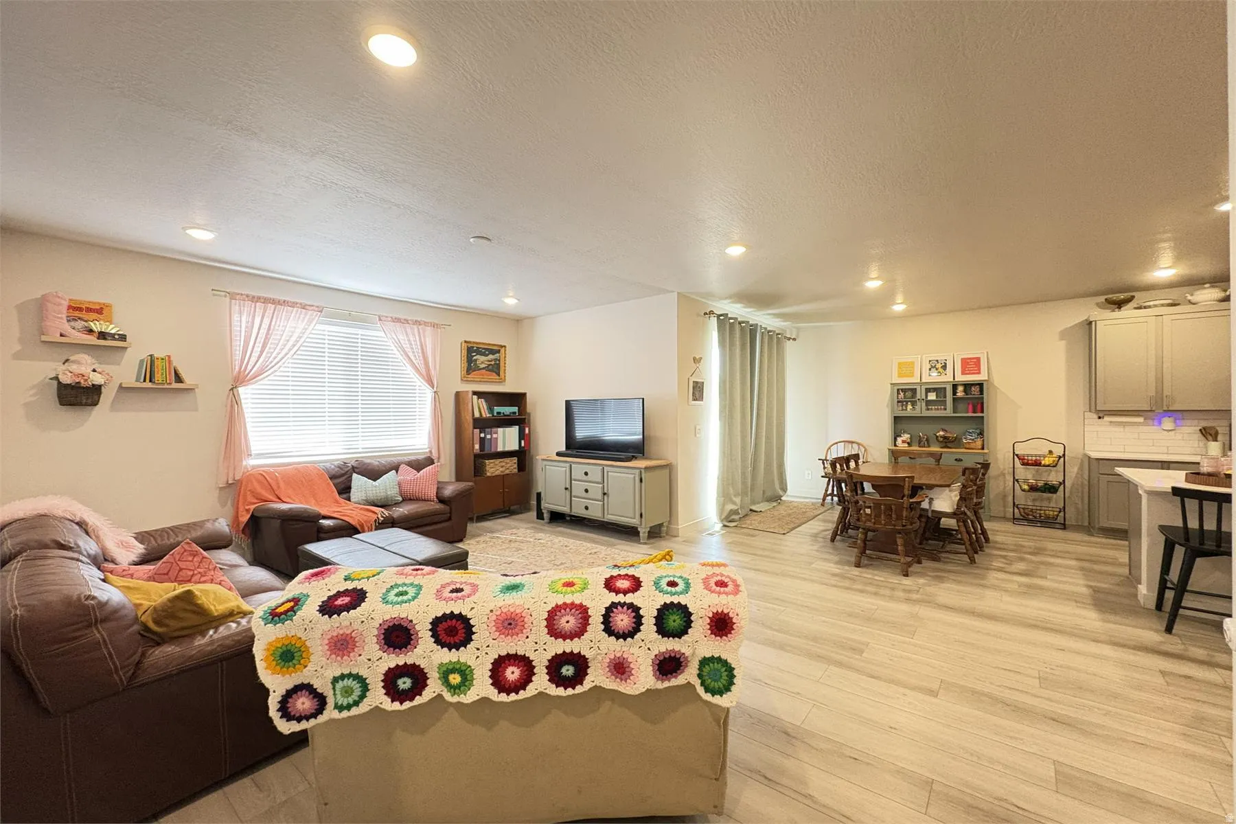 Recessed lighting, wood-finish flooring, white window blinds, white subway tile backsplash, and light gray cabinetry