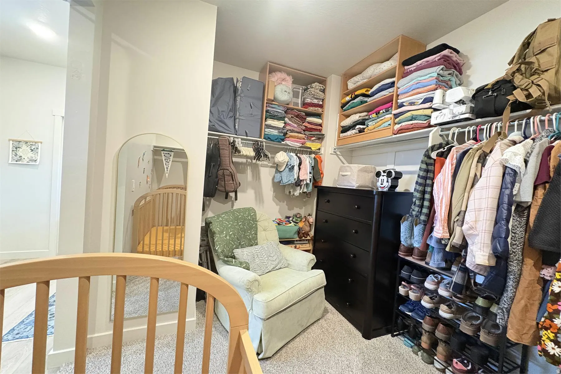 Custom shelving system with built-in clothing rods and wood-finish storage