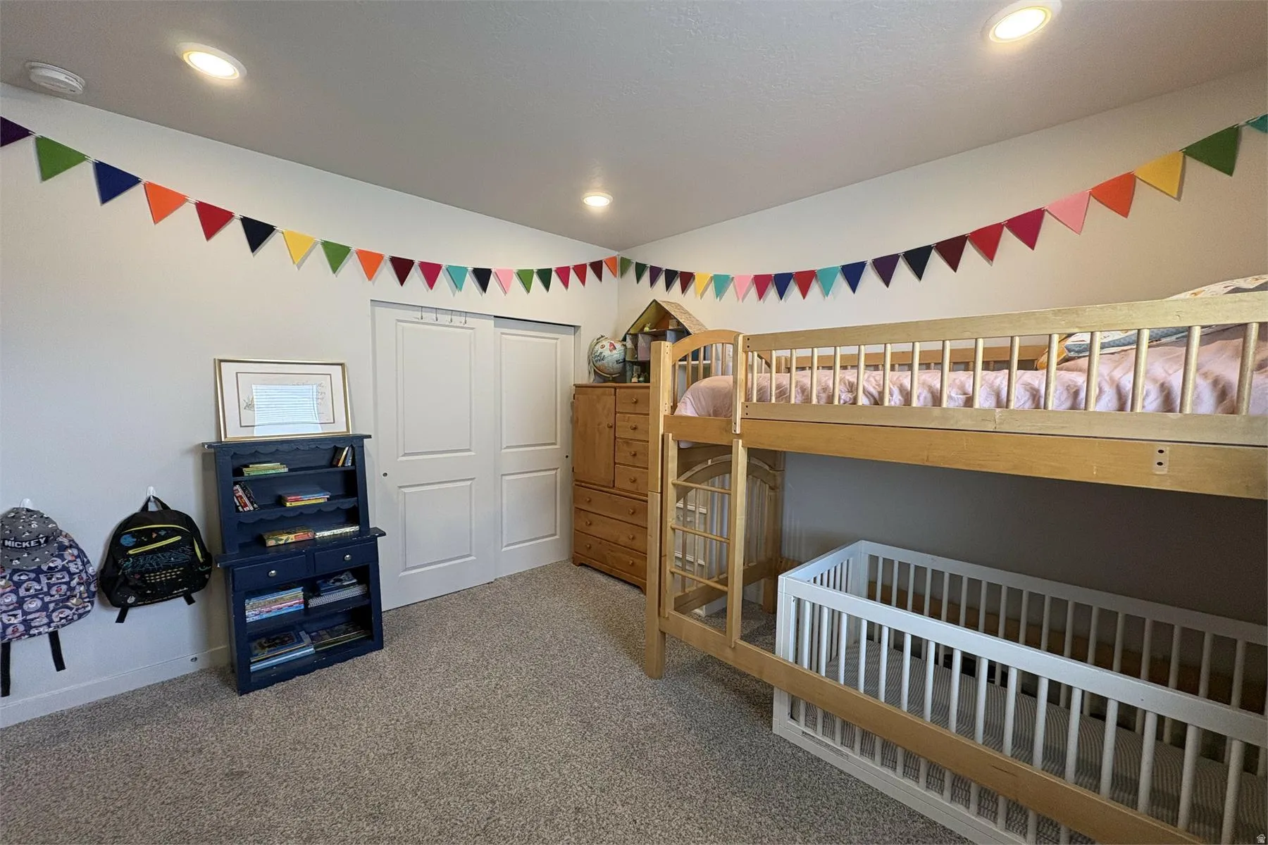 Recessed ceiling lighting, light-toned wall paint, and carpeted flooring